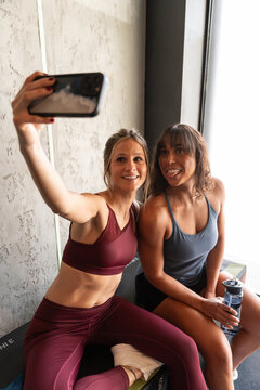 Two fit women taking a selfie after workout in a gym