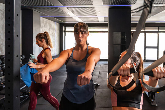 Women doing suspension training workout in modern gym
