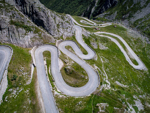 Aerial view of the winding Tremola road with its iconic cobblestone hairpins carved into the steep rocky slopes of the Gotthard Pass in Airolo, Ticino, Switzerland.