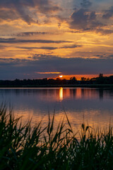 Naklejka premium Sonnenuntergang an einem See mit Spiegelung der Sonne