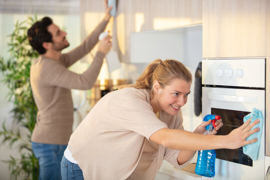 young couple cleaning cleaning modern kitchen