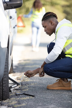 close-up of a worried man looking at punctured car tire