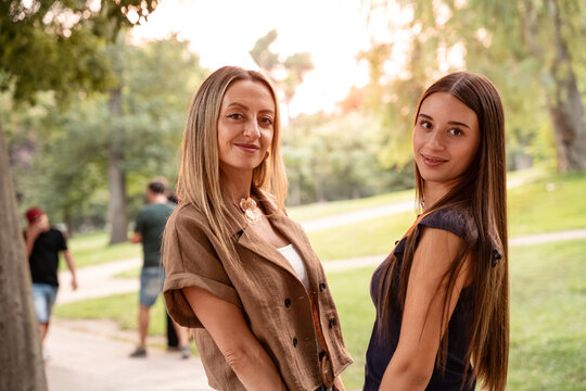 Portrait of mother and daughter smiling together in a sunny park