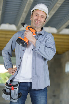 a man posing with a drill