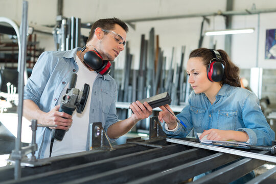 young male and female technicians in metalworks factory
