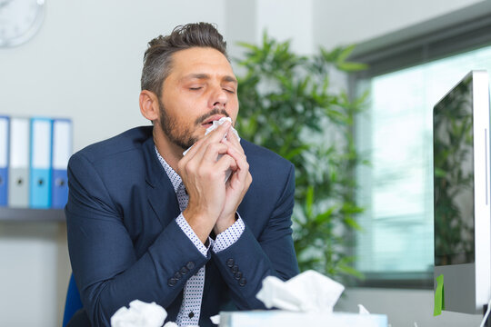 businessman sneezing
