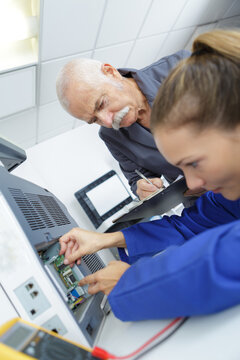 female apprentice fixing a printer
