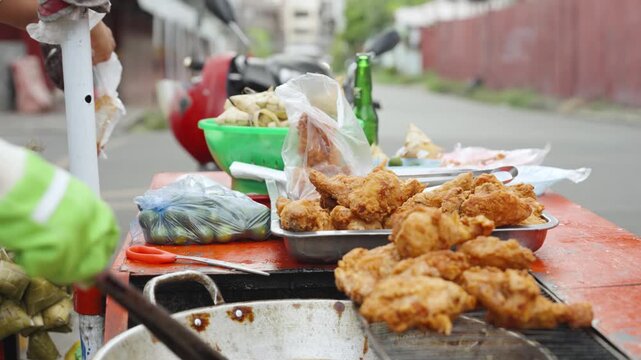 Street Vendor Packing Takeout Fried Chicken While Customer Pays at Market in the Philippines
