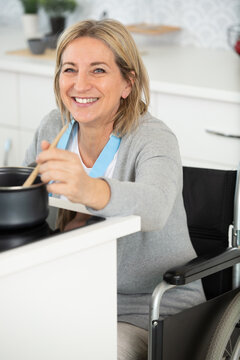 happy disabled woman in wheelchair cooking