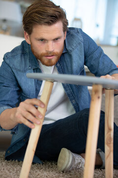 man repairing a wooden table