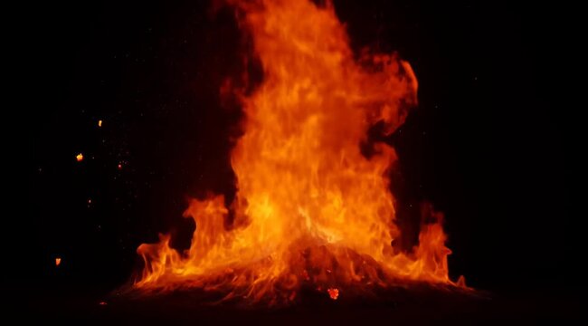 Massive Intense Fire Explosion With Fiery Debris Ascending Against Dark Black Background with Orange Glow and Sparks