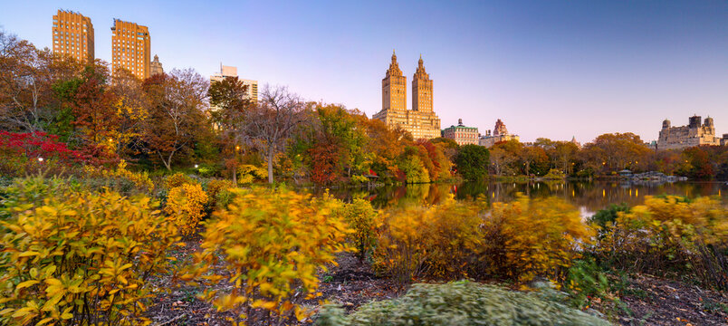 San Remo Building with utumn foliage and urban skyscrapers reflect in the calm lake of a popular tourism destination during the fall season in Central Park, Manhattan, New York City, USA.