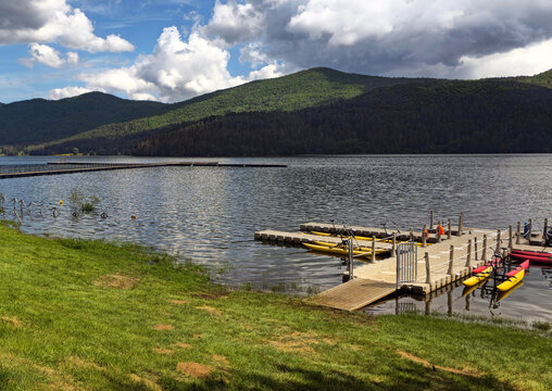 Mountain lake with floating docks and pedal boats surrounded by pine forests in Sila National Park