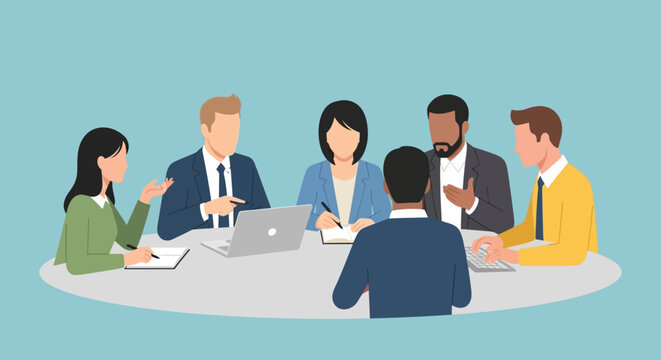 Business team in meeting around circular table with laptops and documents