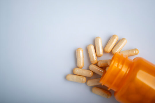 Health care background of pills and bottle on white surface flat lay