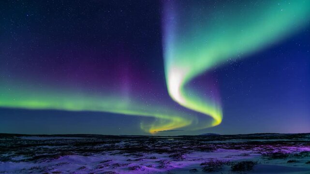 Shifting auroral ribbon tightening, brightening and sweeping over snowy tundra, triggered by storm