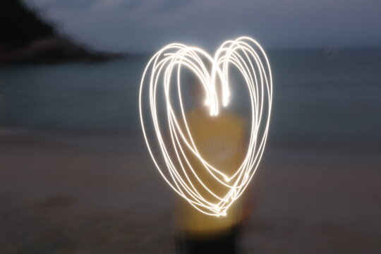 흐릿한 밤바다 앞 하트 모양 라이트 페인팅(Heart Shaped Light Painting on Night Beach)