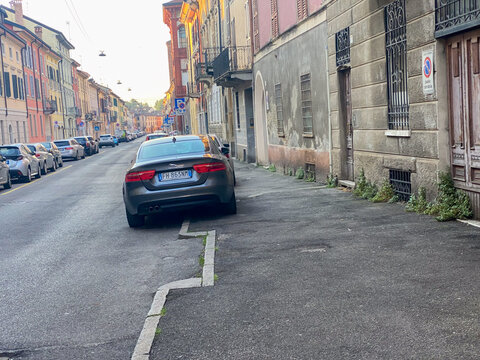Jaguar XE luxury sedan parked on a historic street in Italy, representing modern city lifestyle
