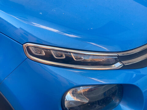 Blue Citroen C3 hatchback showing its distinctive front and LED daytime running lights, a detail highlighting modern automotive design