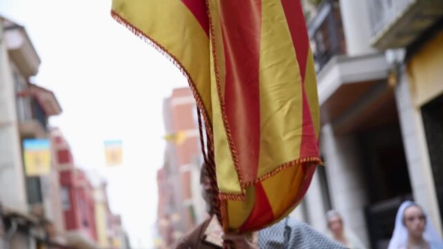 Tilt down of the historic Senyera flag on an authentic Fallas festival banner