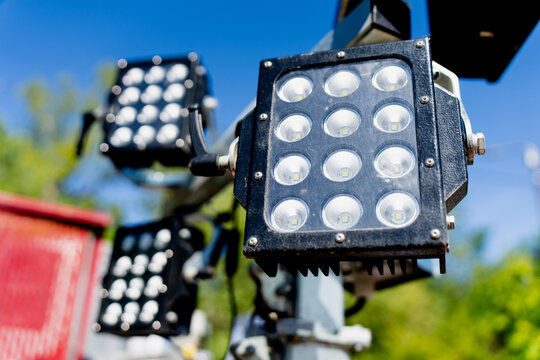 Industrial LED floodlight matrix mounted on a mobile lighting tower mast at a construction site for evening shift work and infrastructure development safety management