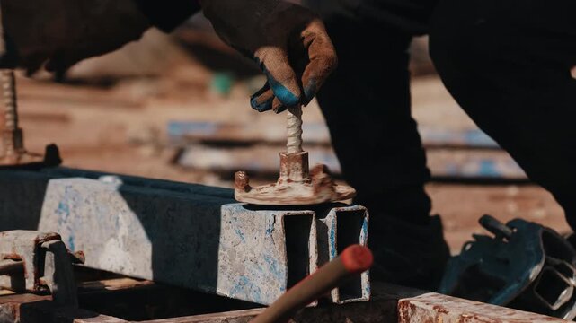 Worker tightening formwork anchor bolt during concrete formwork assembly