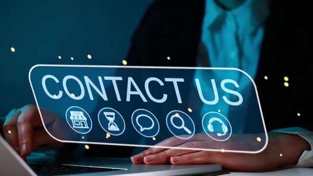 Person using a laptop with a contact us graphic on the screen during evening hours in an office setting