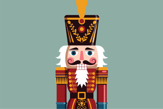 Traditional colorful wooden nutcracker soldier doll standing straight on a muted blue background for holiday decoration.