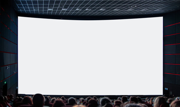 An audience sits in a dark cinema hall looking at a large blank white projection screen.
