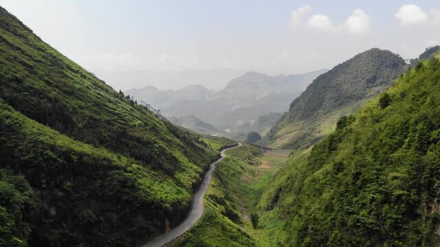 Aerial drone flight over winding mountain pass road &ndash; Ha Giang Loop, Vietnam