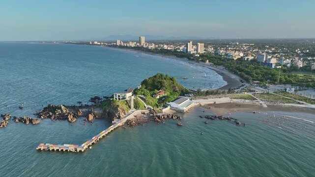 Aerial view of Lan Chau Island, rocky shoreline, and Cua Lo Beach with hotels and urban development along the coast.