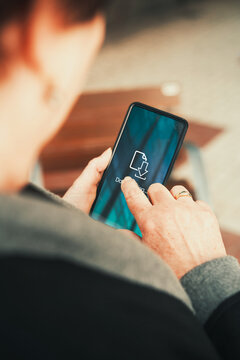 Woman Downloading Files on Smartphone over Teal Screen. File transfer, app updates, mobile data, cloud storage, and digital productivity.