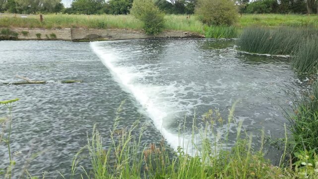 Water Newton, Cambridgeshire, England, UK - June 01 2026: Water Newton Nature Trail, At the Weir watching down stream at the fast flowing water