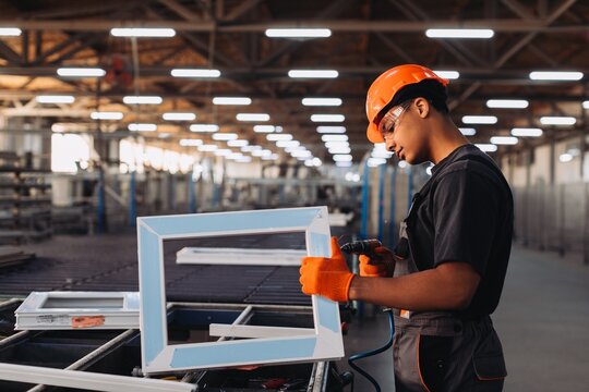 Factory worker assembling pvc window frame manufacturing