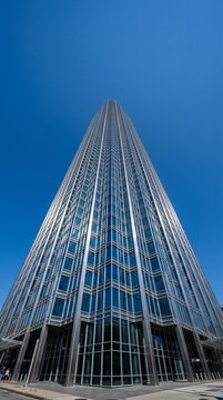 Modern Glass Skyscraper Reaching Towards a Clear Blue Sky