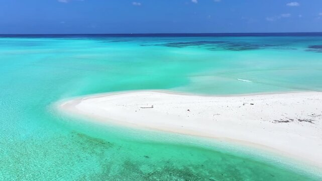 Aerial view of a pristine white sandbank surrounded by crystal clear turquoise ocean water under a bright blue sky in Fulhadhoo, Baa Atoll, Maldives.