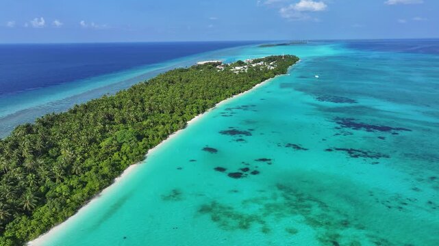 Aerial view of the lush tropical island with white sand beaches and turquoise coral reefs in Fulhadhoo, Baa Atoll, Maldives.