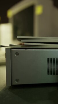 Various computer parts are scattered on a work table. Tools and devices are present for repairing and assembling computer equipment. Light from the workshop illuminates the scene.