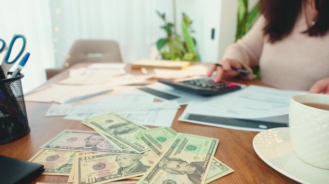 Porocess work financial department accountant calculating corporate budget planning cash flow at office desk. Two business woman, hands on documents analyzing expenses, using calculator paper invoices