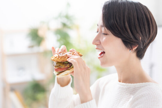 ハンバーガーを食べる女性