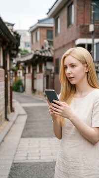 도시에서 스마트폰을 보는 외국인 여성 / Foreign Woman Using a Smartphone in the City