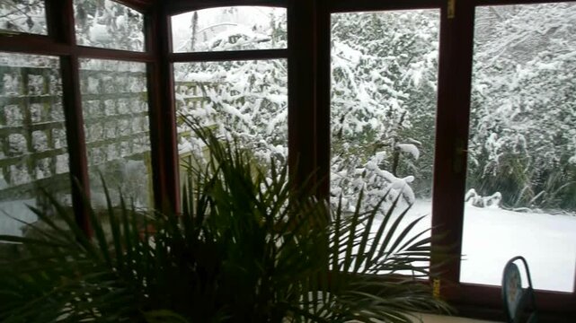 Heavy snow falling on an English Country Cottage garden. Worcestershire, England, UK