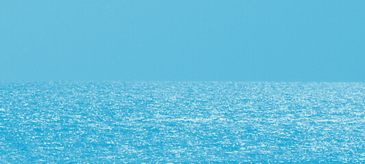 Wide panoramic shot of blue ocean water surface meeting clear sky at horizon under bright sunlight creating beautiful seascape background for travel advertising or summer vacation holiday travel theme © Nusrat