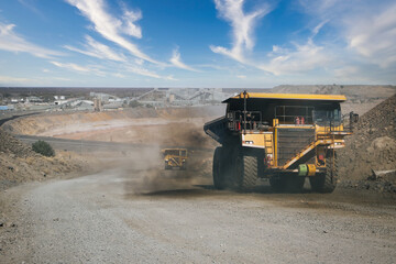 : Mining dump truck transporting earth material at an open pit mine site © poco_bw