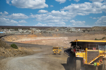 : Mining dump truck transporting earth material at an open pit mine site © poco_bw