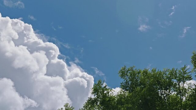 ow angle view of dramatic fluffy clouds forming in the blue sky during daytime