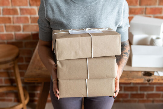 Person holding stack of packages.