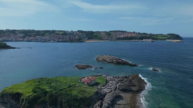 Aerial shot of Isla del Carmen and the scenic coastline of Luanco in Asturias, Spain, showing the village and blue sea