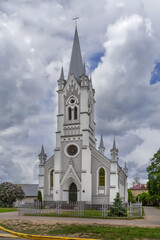 Fototapeta premium Main facade of Lutheran Church in Grodno, Belarus. Neo Gothic architecture landmark with tall bell tower in daylight