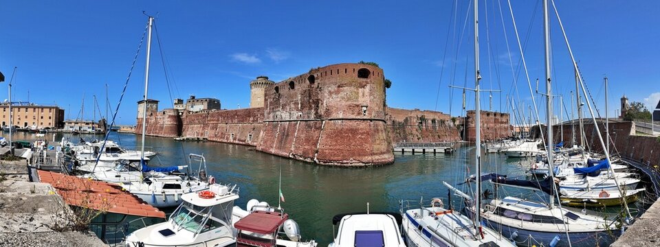 Livorno, Tuscany, Italy - 06.27.2026: view of Historic Old fortress with a moat and docked sailboats, showcasing Livorno's maritime heritage and architecture